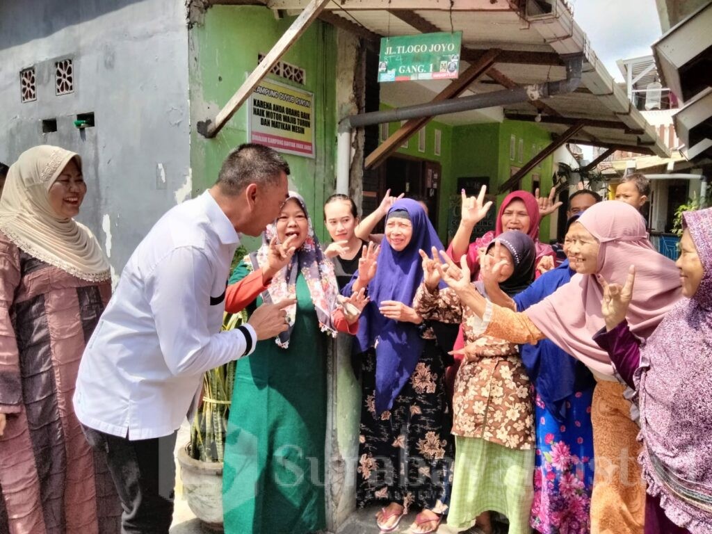 Ratusan warga sekitar menyambut kedatangan Abah Anton bersama istri menuju TPS 002 Kelurahan Tlogomas