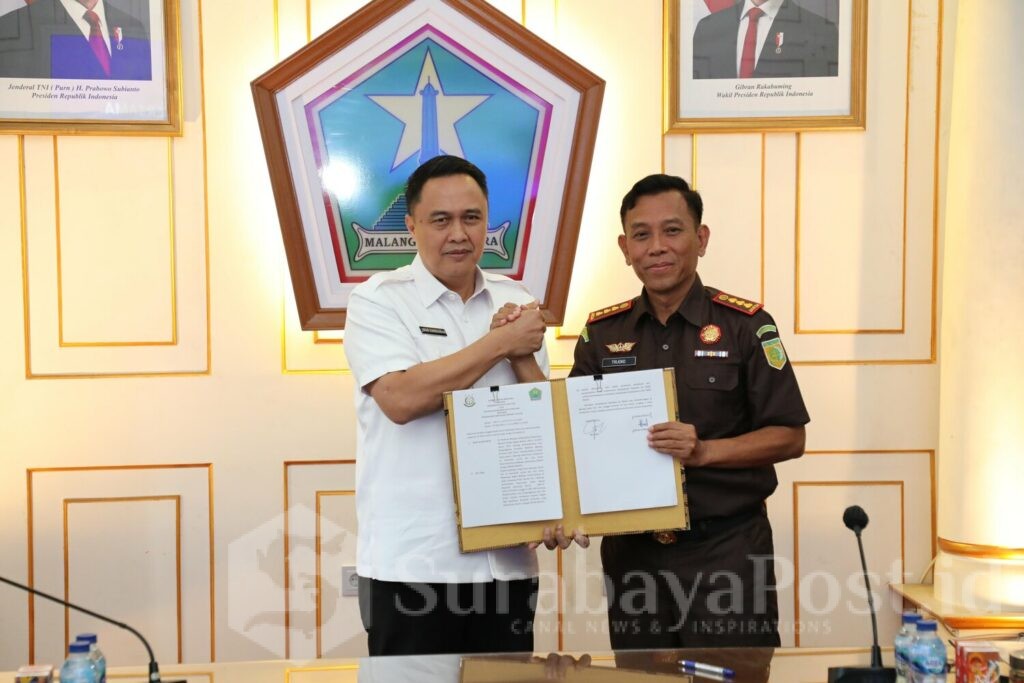 Pj Walikota Malang, Iwan Kurniawan dan Kepala Kejaksaan Negeri Kota Malang, Tri Joko menunjukkan bukti MoU yang telah ditandatangani. (Sumber Prokompim)