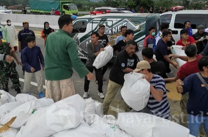 Masyarakat dan relawan bahu membahu memindahkan pakan ternak yang tercecer dari truk pasca ensiden Maut. (ist)