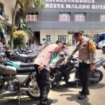 Kasatlantas Polresta Malang Kota Kompol Agung Fitriansyah bersama KabagOps AKP Sutomo menunjukkan ratusan motor hasil penindakan aksi balap liar.