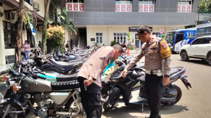 Kasatlantas Polresta Malang Kota Kompol Agung Fitriansyah bersama KabagOps AKP Sutomo menunjukkan ratusan motor hasil penindakan aksi balap liar.