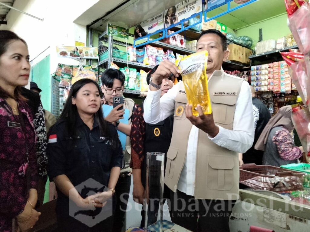 Walikota Malang, Wahyu Hidayat menunjukkan kemasan minyak goreng yang akan ditakar