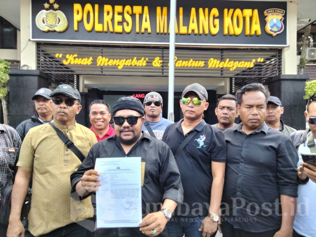 Koordinator aksi, Damanhury Jab bersama peserta aksi menunjukkan bukti laporan ke Polresta Malang Kota