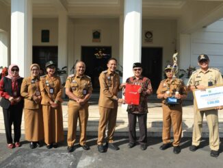 Walikota Malang, Dr. Ir. Wahyu Hidayat, MM, menyerahkan piagam penghargaan dan piala kepada para pemenang Lomba Kampung Mbois, Senin 5 Mei 2025. Sumber Prokompim).