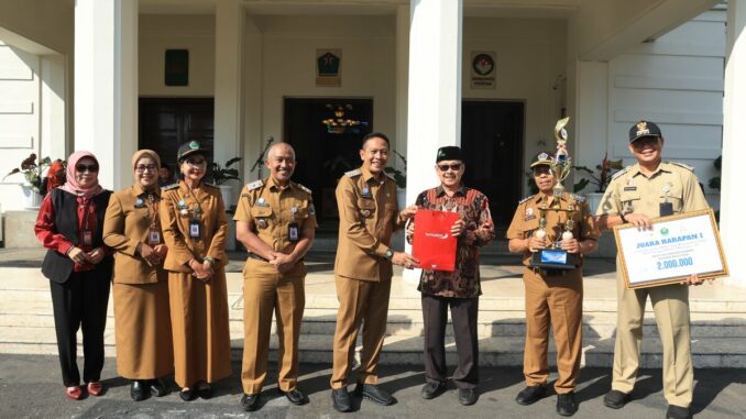 Walikota Malang, Dr. Ir. Wahyu Hidayat, MM, menyerahkan piagam penghargaan dan piala kepada para pemenang Lomba Kampung Mbois, Senin 5 Mei 2025. Sumber Prokompim).