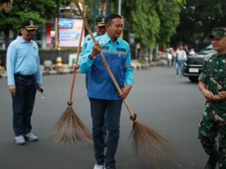 Wali Kota Malang, Dr. Ir. Wahyu Hidayat, M.M., turut turun tangan membersihkan trotoar. Nampak ia memegang sikat dan mulai menggosok trotoar yang sebelumnya terlihat kusam dan berdebu. (Sumber Prokompim).