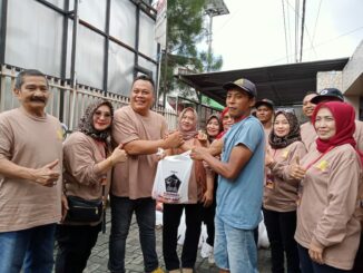 Ketua Panitia Kurban, Danny Agung Prasetyo menyerahkan paket daging kurban ke salah satu penerima, Minggu (8/6/2025).