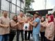 Ketua Panitia Kurban, Danny Agung Prasetyo menyerahkan paket daging kurban ke salah satu penerima, Minggu (8/6/2025).