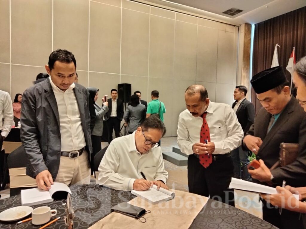 Ketua DPN Peradi, Luhut M.P. Pangaribuan menandatangani buku hasil karyanya yang diberikan ke advokat muda peserta bedah buku