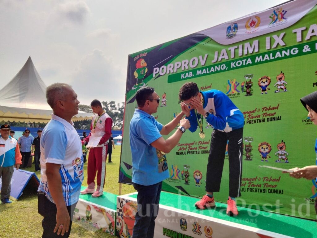 Walikota Malang, Wahyu Hidayat mengalungkan medali emas ke atlet Cabor atletik Farid Radvan