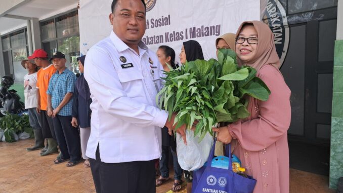 Kepala Lapas Kelas I Malang, Teguh Pamuji memberikan bantuan paket sembako dan hasil panen kepada keluarga warga binaan. (Sumber L'SIMA).