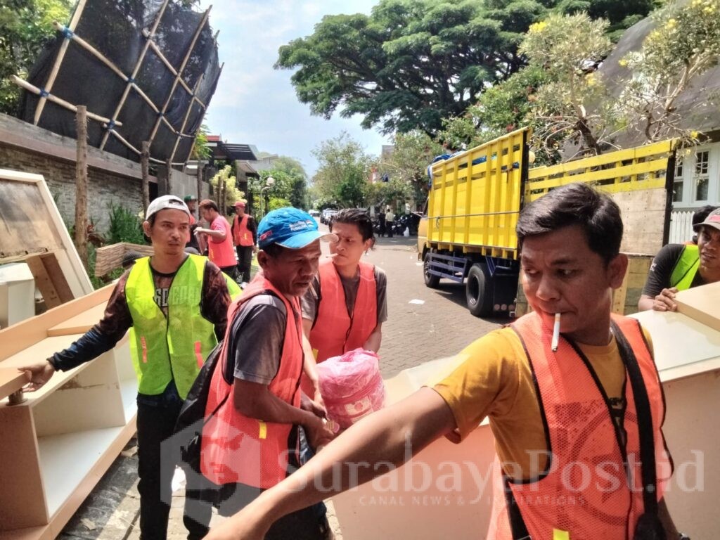 Sejumlah petugas juru angkut memindahkan barang dari rumah berlantai dua ke mobil Truk.