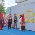 Kepala Disdikbud Kota Malang, Suwarjana, SE, MM, menyerahkan trophy dan piagam penghargaan kepada salah satu kategori pemenang lomba di Museum Mpu Purwa, Kamis (6/11/2025).