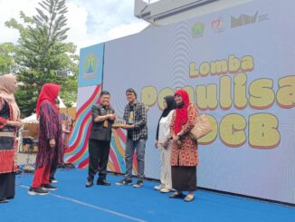 Kepala Disdikbud Kota Malang, Suwarjana, SE, MM, menyerahkan trophy dan piagam penghargaan kepada salah satu kategori pemenang lomba di Museum Mpu Purwa, Kamis (6/11/2025).