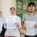 MENANG: Helly, SH, MH, kuasa hukum Tatik Suwartiatun (tengah) dan Sasa (putri Tatik) menunjukkan hasil putusan PN Bangil yang memenangkan permohonan praperadilan, Jumat (28/11/2025).