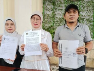 MENANG: Helly, SH, MH, kuasa hukum Tatik Suwartiatun (tengah) dan Sasa (putri Tatik) menunjukkan hasil putusan PN Bangil yang memenangkan permohonan praperadilan, Jumat (28/11/2025).