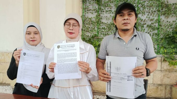 MENANG: Helly, SH, MH, kuasa hukum Tatik Suwartiatun (tengah) dan Sasa (putri Tatik) menunjukkan hasil putusan PN Bangil yang memenangkan permohonan praperadilan, Jumat (28/11/2025).