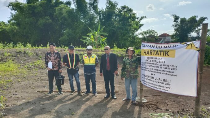 Solikin didampingi Djoko Tritjahjana, SH, MH selaku kuasa hukumnya, memasang banner yang menunjukkan lahan itu adalah milik istrinya berdasar Akta Jual Beli yang dikeluarkan PPAT, Senin (29/12/2025).