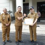 Wali Kota Malang, Dr. Ir. Wahyu Hidayat, MM, menyerahkan piagam penghargaan dari Gubernur Jawa Timur, Khofifah Indar Parawansa, kepada Dinas Kesehatan Kota Malang. (Sumber Prokompim).