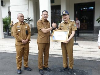 Wali Kota Malang, Dr. Ir. Wahyu Hidayat, MM, menyerahkan piagam penghargaan dari Gubernur Jawa Timur, Khofifah Indar Parawansa, kepada Dinas Kesehatan Kota Malang. (Sumber Prokompim).