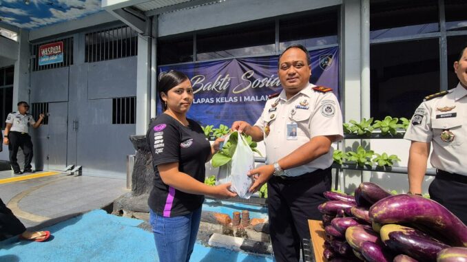 Kalapas Kelas I Malang, Teguh Pamuji, menyerahkan 100 paket sayur hasil panen brandgang kepada keluarga warga binaan. (Sumber L'SIMA).