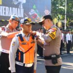Polresta Malang Kota Gelar Ops Keselamatan Semeru 2026, Libatkan 85 Personel Gabungan MALANGKOTA (SurabayaPost.id) - Polresta Malang Kota menggelar apel pasukan gabungan Operasi Keselamatan Semeru 2026 di halaman Mapolresta Malang Kota, Senin (2/2/2026). Operasi ini bertujuan menciptakan kepatuhan dan kesadaran kamseltibcarlantas yang aman, tertib, dan kondusif menjelang meningkatnya mobilitas warga pada Ramadan dan Idulfitri 2026. Apel penyematan pita biru oleh Kabag Ops Polresta Malang kota Kompol Wiwin Rusli melibatkan 85 personel gabungan dari unsur Polri, TNI, Dinas Perhubungan Kota Malang, serta Satpol PP Kota Malang. Kasatlantas Polresta Malang Kota, AKP Rio Angga Prasetyo, menjelaskan bahwa Ops Keselamatan Semeru 2026 dilaksanakan selama dua pekan (mulai 2 hingga 15 Februari 2026) dengan pendekatan preemtif dan preventif. "Kami sosialisasi dan edukasi tertib berlalu lintas, penerapan tidak hanya dijalanan saja, namun juga menyasar sekolahan, mulai dari anak usia TK, pelajar, hingga mahasiswa, supaya kesadaran itu tumbuh sejak dini," terang AKP Rio. Satlantas juga meningkatkan intensitas patroli di ruang publik dan titik rawan kepadatan yang memiliki potensi kemacetan. "Patroli preventif di lokasi-lokasi yang berpotensi peningkatan volume kendaraan. Contohnya di kawasan Alun-Alun Merdeka Kota Malang yang kini ramai dikunjungi," jelasnya. Terkait penegakan hukum, AKP Rio menegaskan pihaknya lebih mengoptimalkan kamera tilang elektronik (E-TLE) mobile dan membatasi penindakan secara langsung. "Penindakan tetap ada, namun kami perkuat dengan E-TLE mobile dan meminimalisir tilang langsung," ungkap AKP Rio. Dalam Operasi Keselamatan Semeru 2026, terdapat 10 jenis pelanggaran prioritas, termasuk boncengan lebih dari satu orang, melebihi batas kecepatan, dan pengendara di bawah umur. Polresta Malang Kota mengajak masyarakat menjadi bagian dari keselamatan itu sendiri dengan menumbuhkan sikap saling menghargai di jalan raya. (lil).