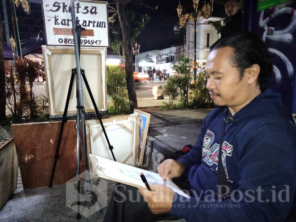 Aji, pelukis sketsa saat menorehkan goresan tinta di kertas
