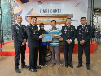 Kalapas Kelas 1 Malang, Christo Victor Nixon Toar, menyerahkan gerobak usaha kepada keluarga warga binaan. (Sumber L'SIMA).