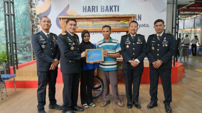 Kalapas Kelas 1 Malang, Christo Victor Nixon Toar, menyerahkan gerobak usaha kepada keluarga warga binaan. (Sumber L'SIMA).