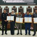 Ketua DPRD Kota Malang, Amithya Ratnanggani Sirraduhita dan para wakil ketua serta Wali Kota Wahyu Hidayat menunjukkan surat keputusan yang telah ditandatangani.
