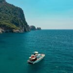 Perairan jernih dengan perahu wisata dan kegiatan menyelam.