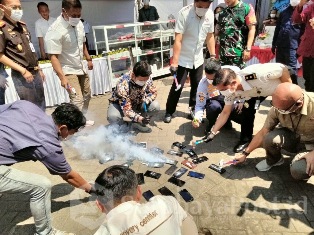 Pemusnahan barang bukti berupa Handphone dengan cara di pukul dengan palu.